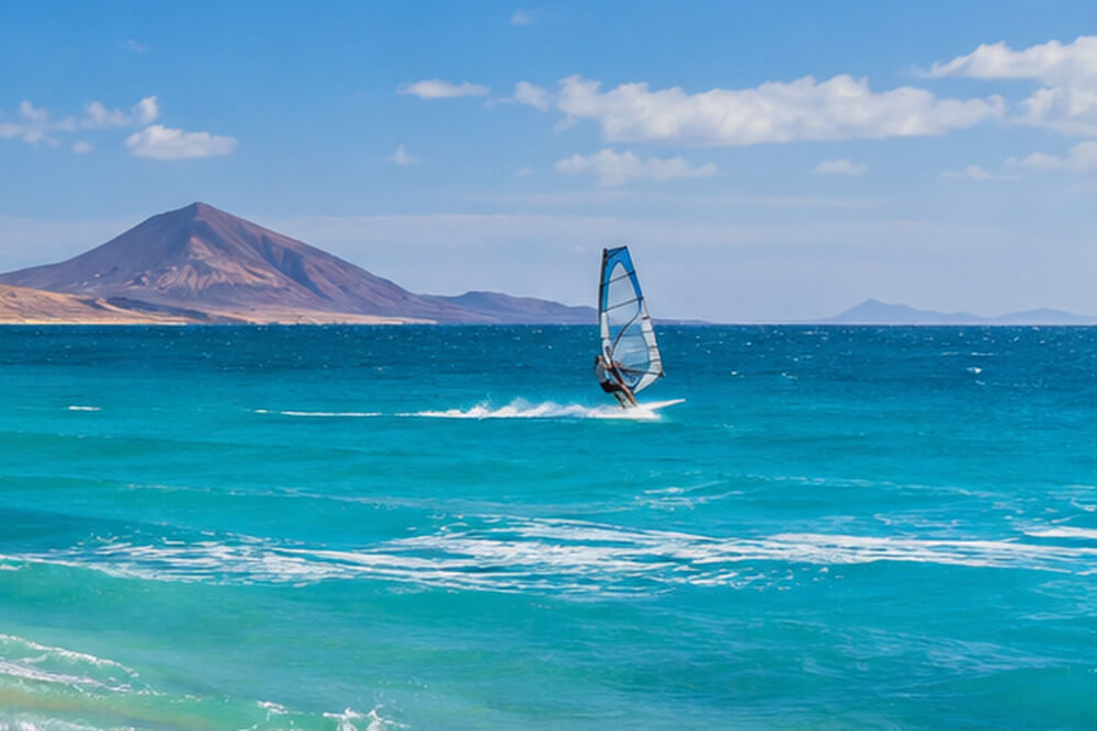 Windsurfer na turkusowym oceanie u wybrzeży Fuerteventury