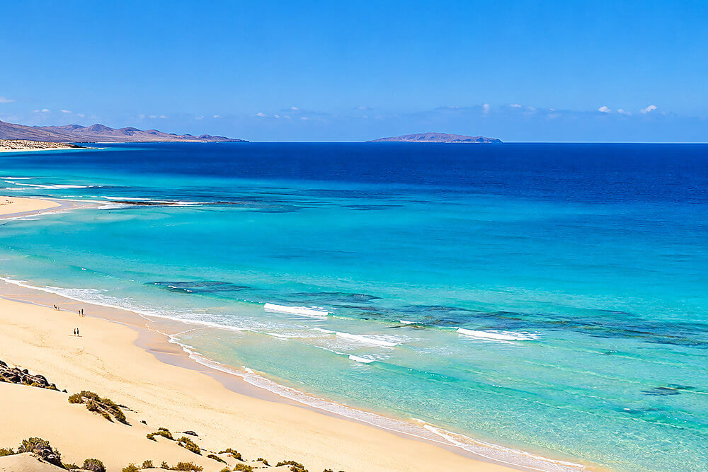 Jasny piasek i wydmy przy plażach Grandes Playas de Corralejo