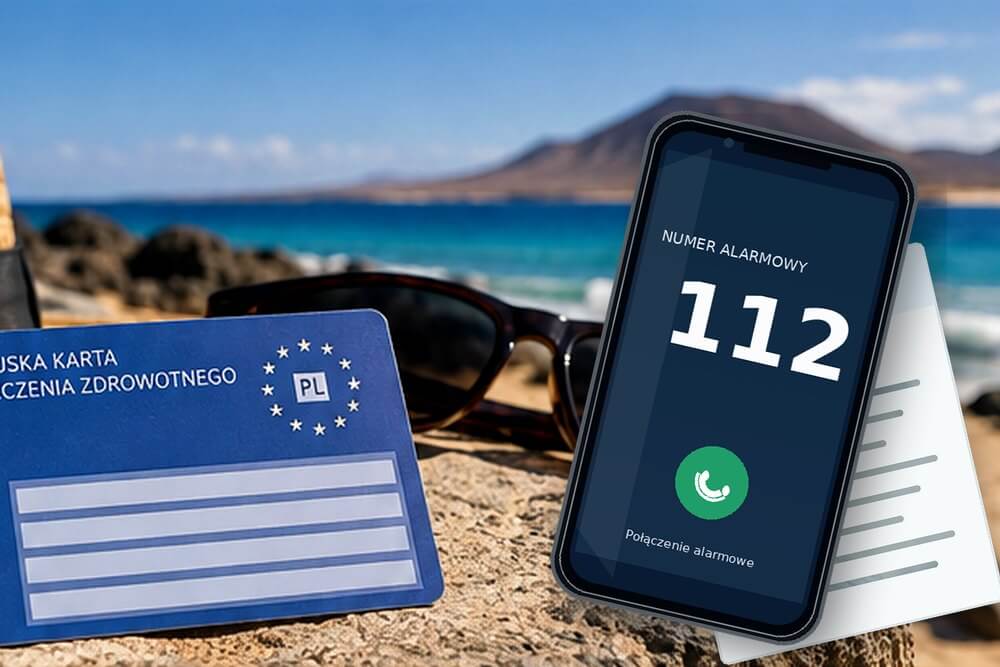 Telefon z numerem 112 obok dokumentów ubezpieczenia podróży